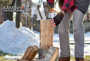 Mann hackt Holzscheite für Kamin